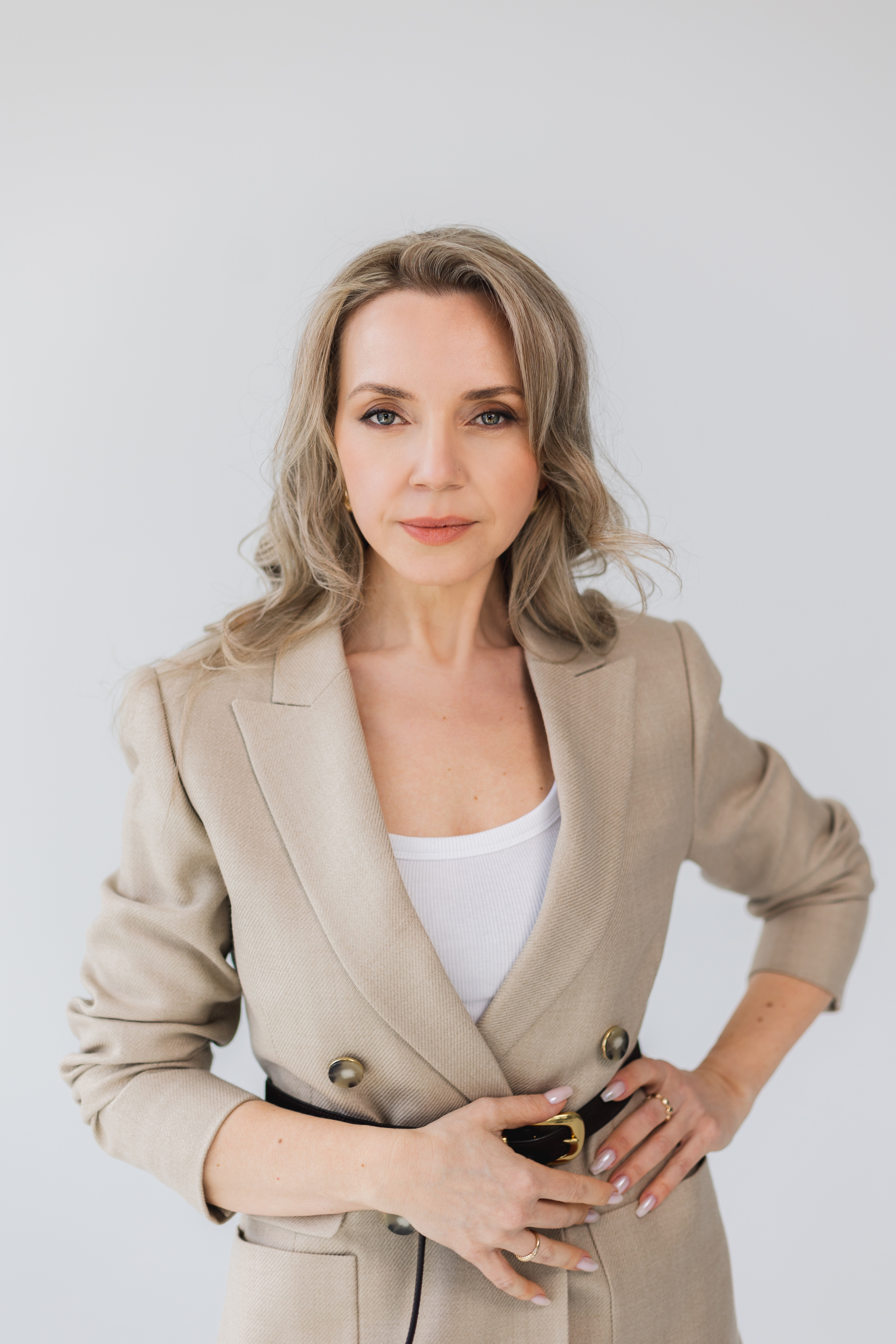 Yana Mamotenko in a tan blazer standing with a confident stance